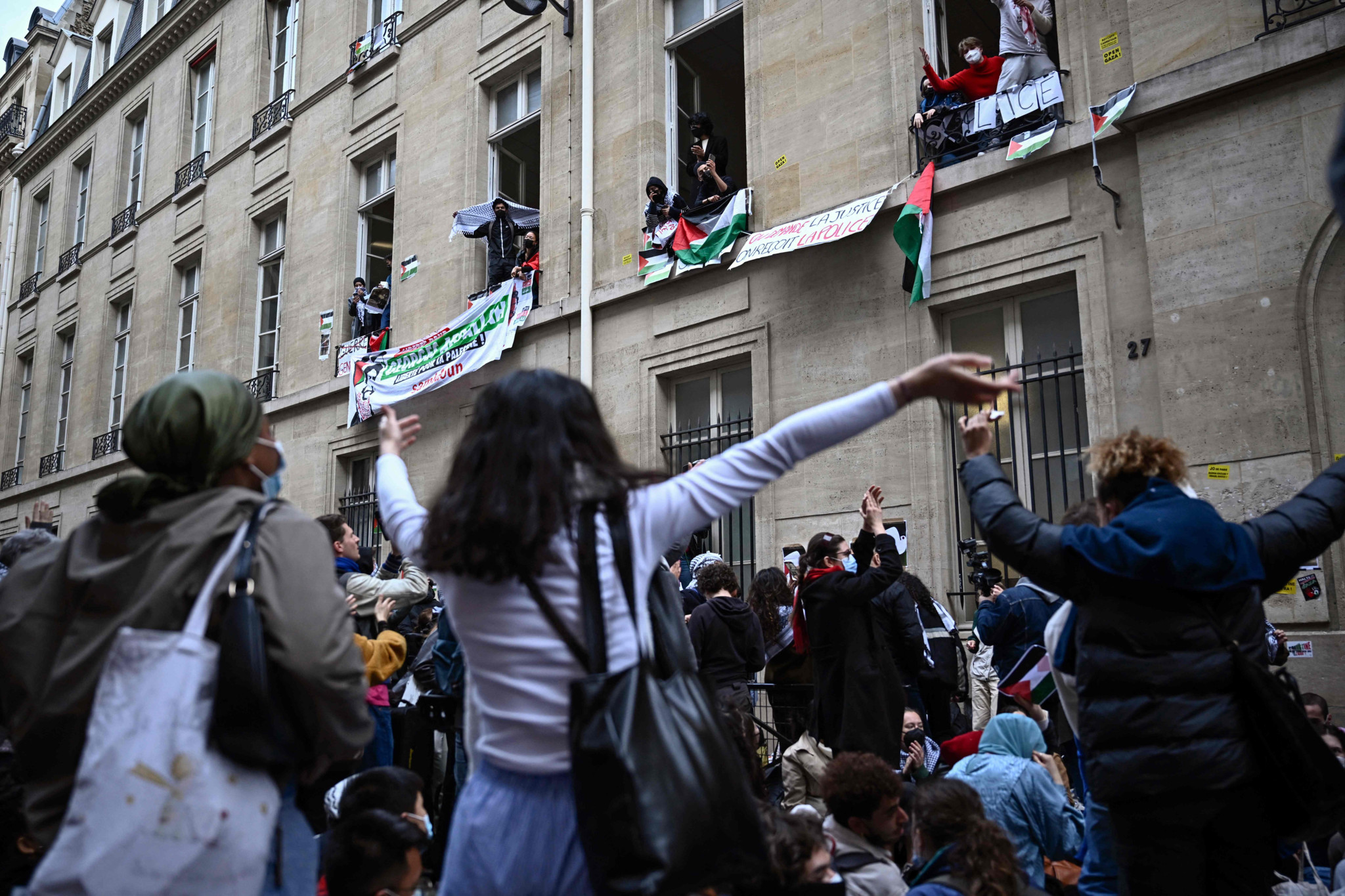 Vendredi devant l’entrée du bâtiment principal de Sciences-Po, rue Saint-Guillaume, des manifestants soutiennent les occupants aux fenêtres.